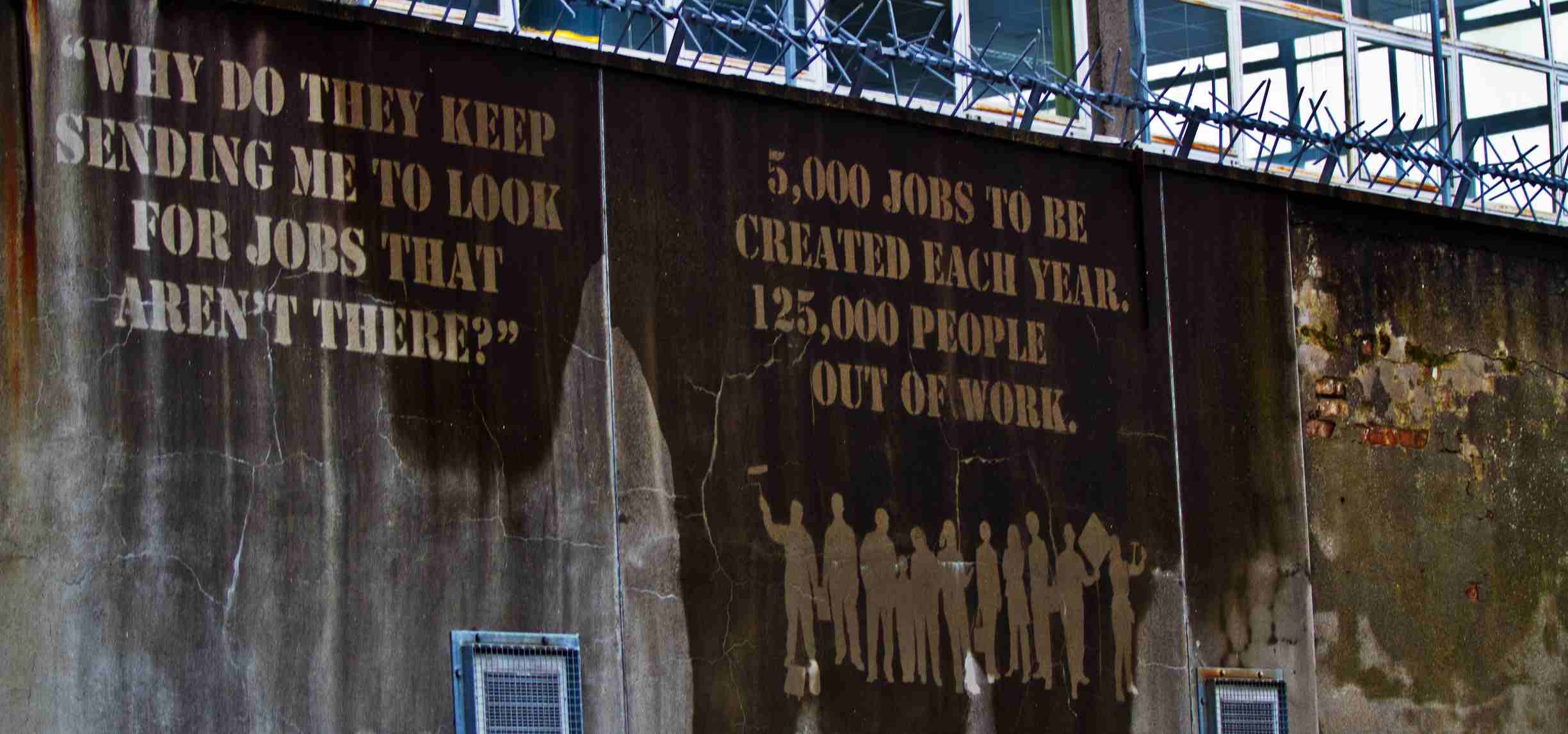 Message stencilled on wall: why do they keep sending me to look for jobs that aren't there?