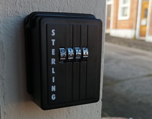 A closed keypad outside a front door with an image of the street as a backdrop. 